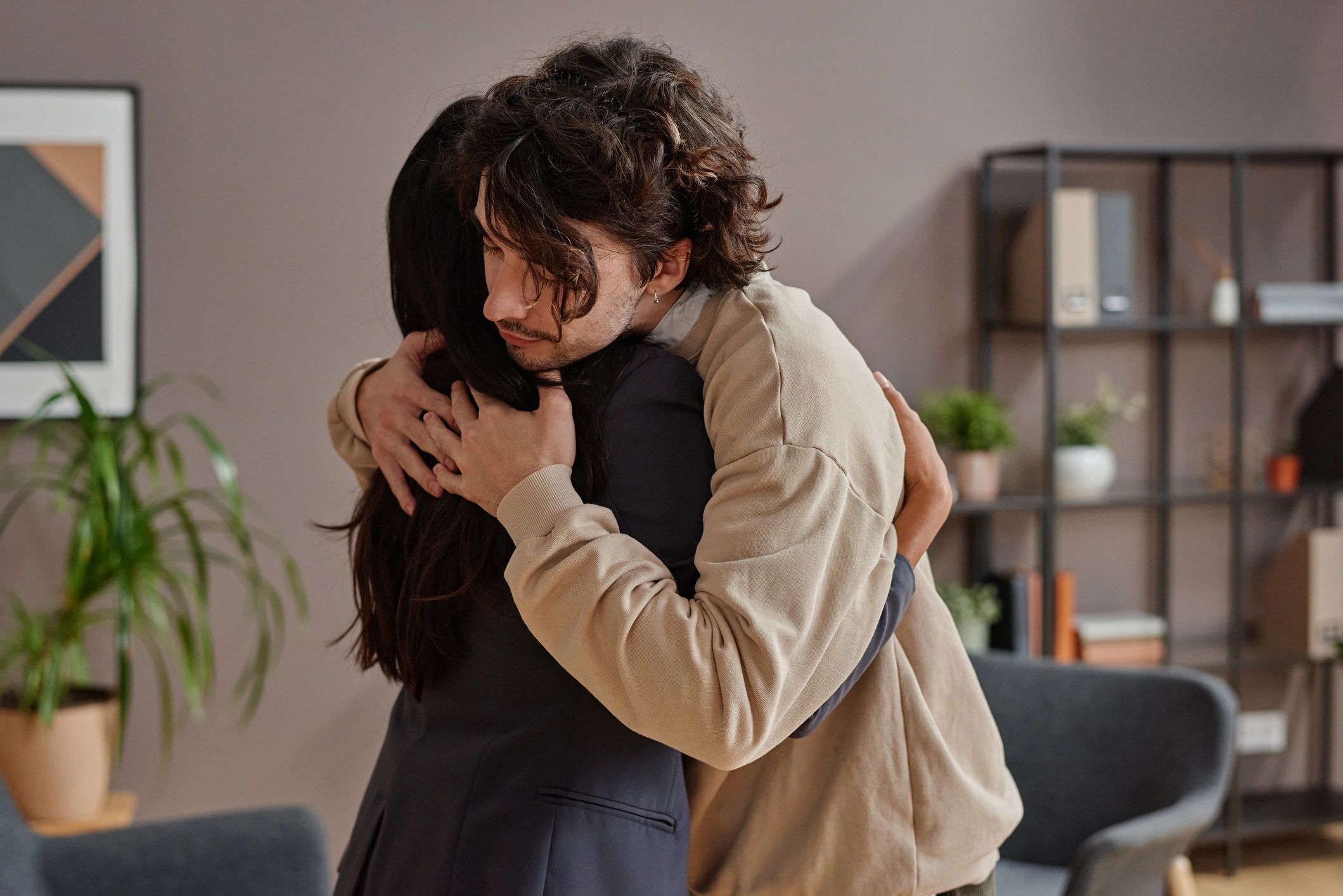 Diverse adult client receiving support from a therapist in a welcoming office