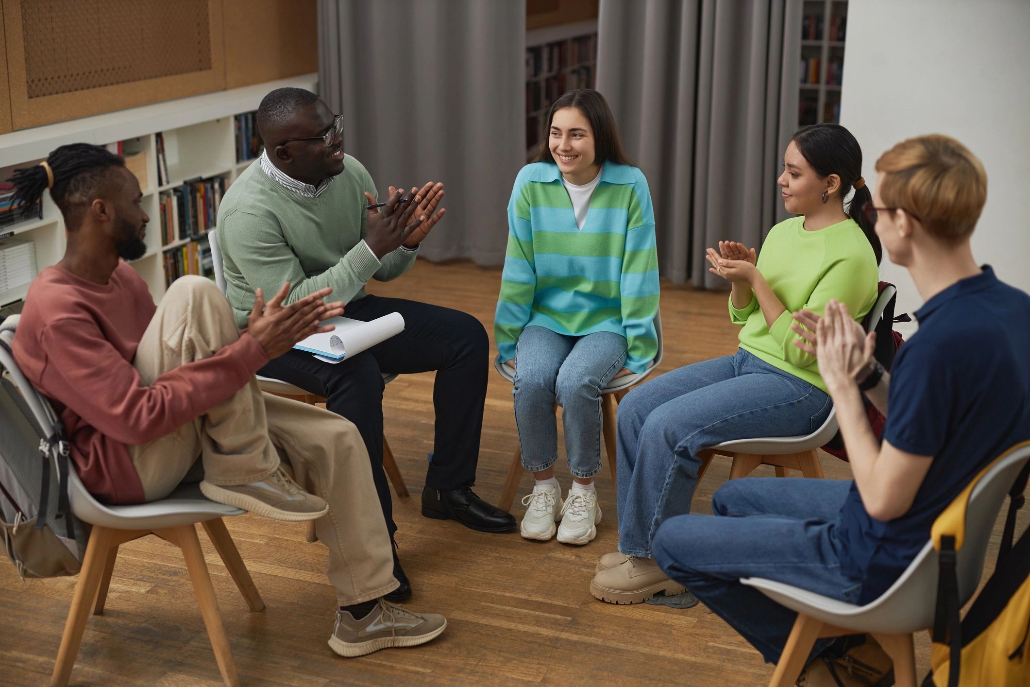 Young people in a supportive group setting celebrating progress