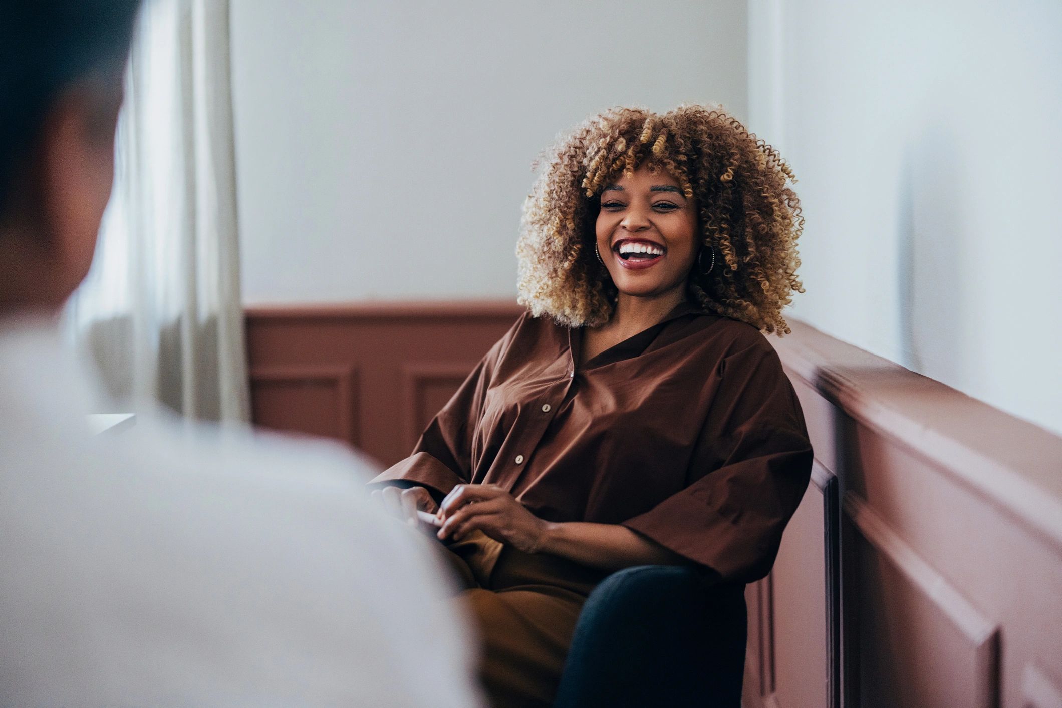 Smiling adult woman in a warm, welcoming therapy setting